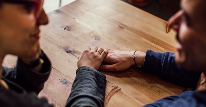 Support - Man and Woman Sitting Together in Front of Table