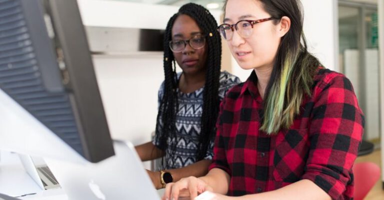 Support - Woman Wearing Red and Black Checkered Blouse Using Macbook