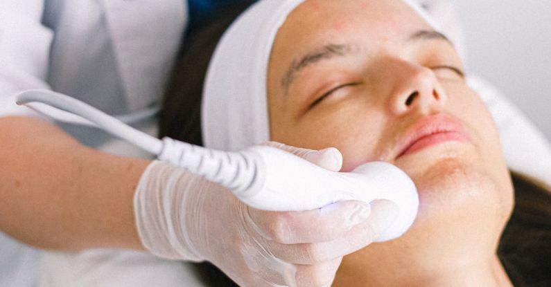 Therapy - Beautician doing ultrasonic face cleaning for young client