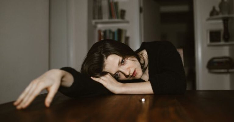 Breakups - A Sad Woman Resting Her Head on a Wooden Table